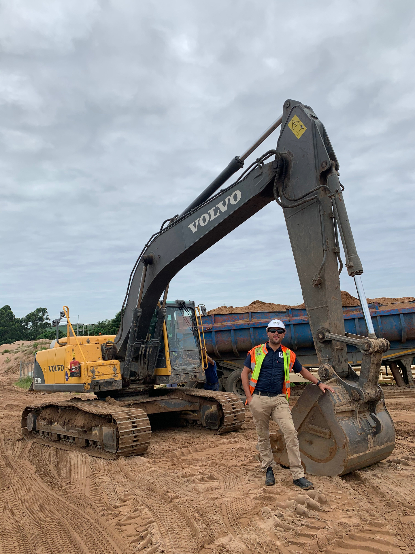 RESS safety officer beside a Volvo excavator and dump truck