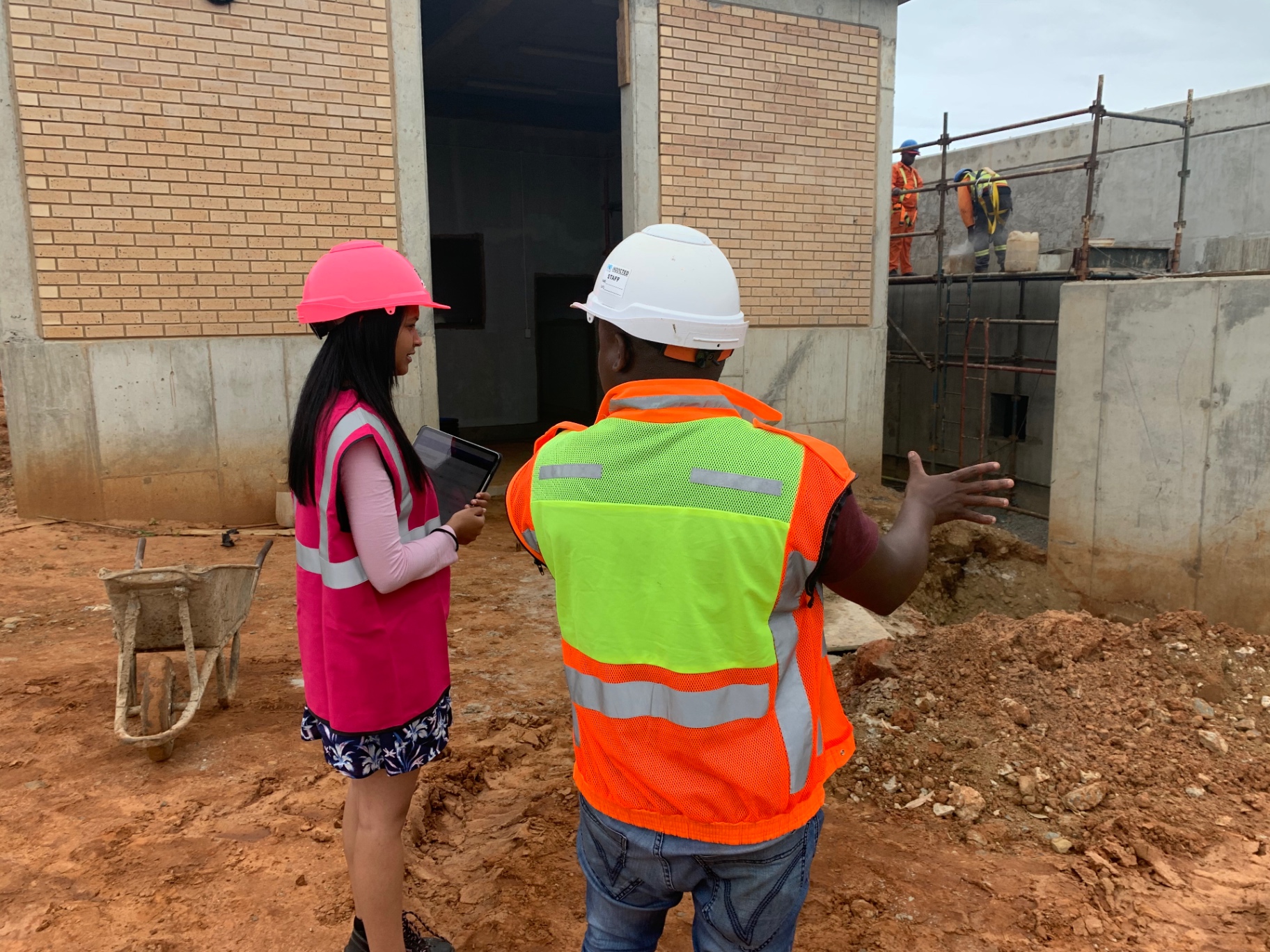 RESS safety officers reviewing a live construction site with scaffolding works behind them