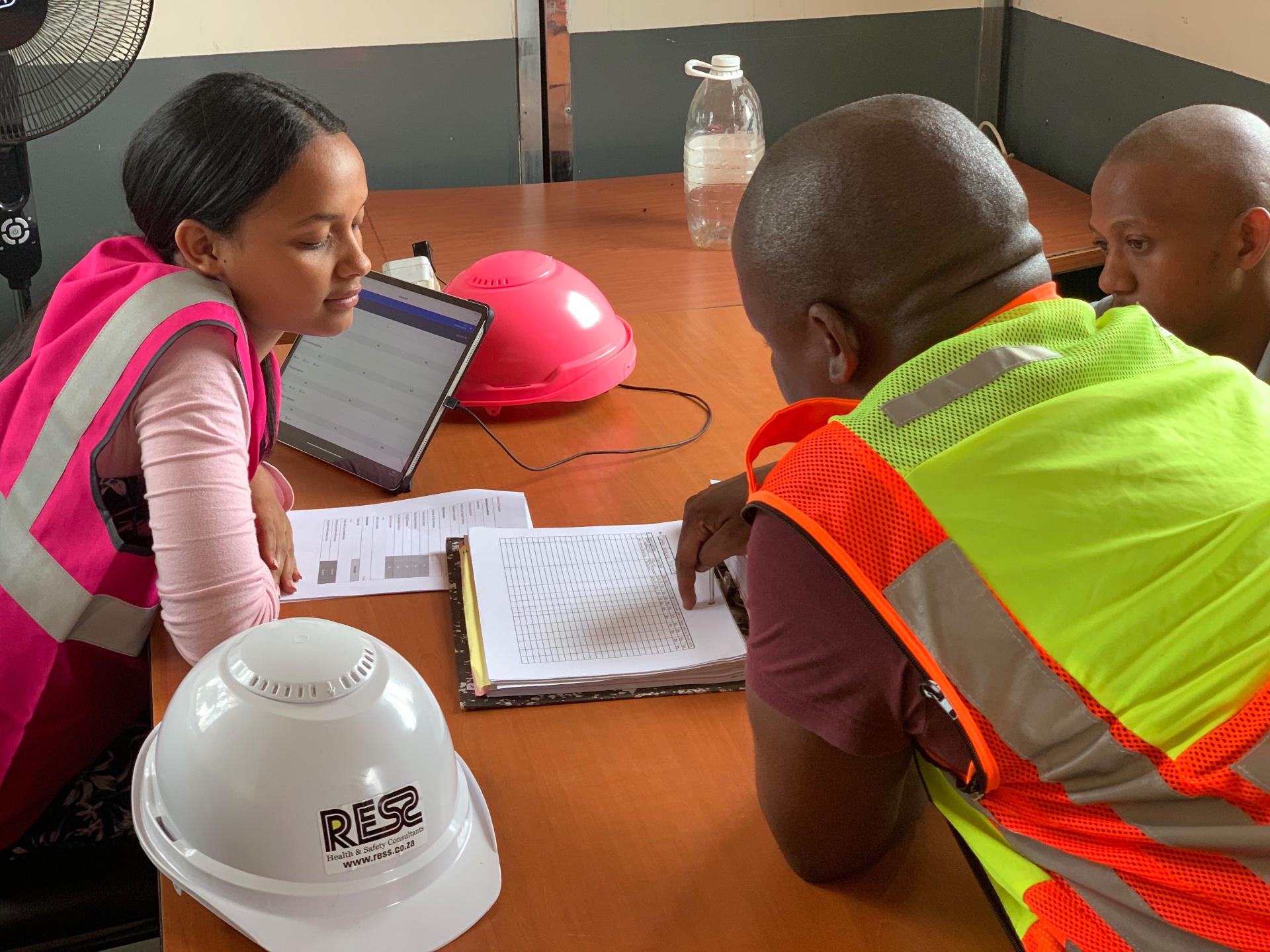 RESS safety officers reviewing documents on a tablet at a site meeting