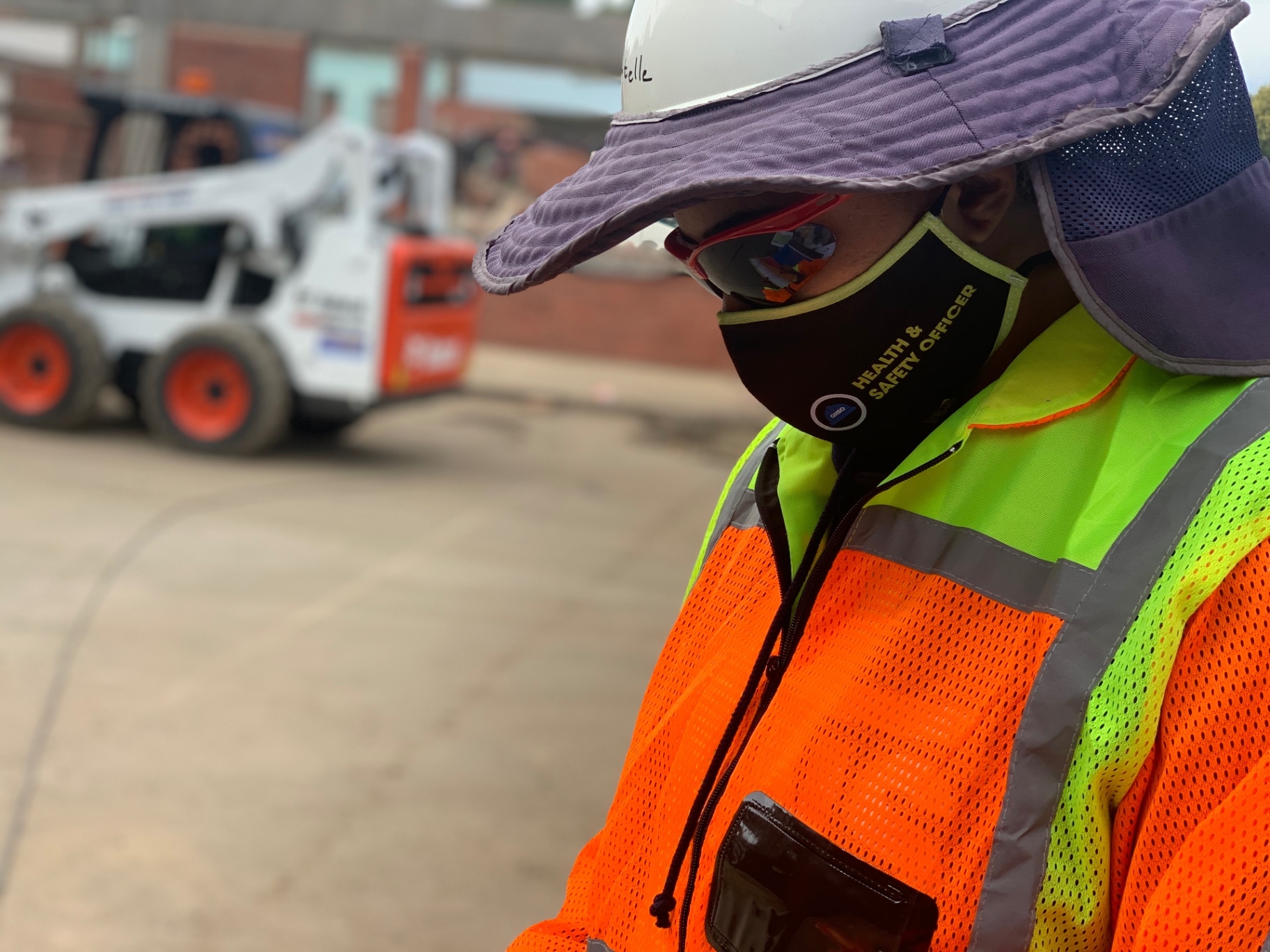 RESS safety officer in full PPE beside construction machinery