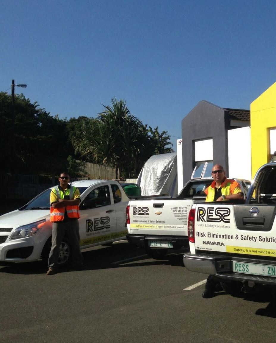 RESS International safety team standing beside branded vehicles